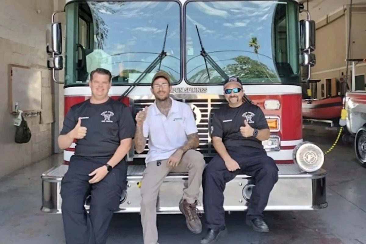 Express Air Duct Cleaning team members giving a thumbs up in front of a fire engine